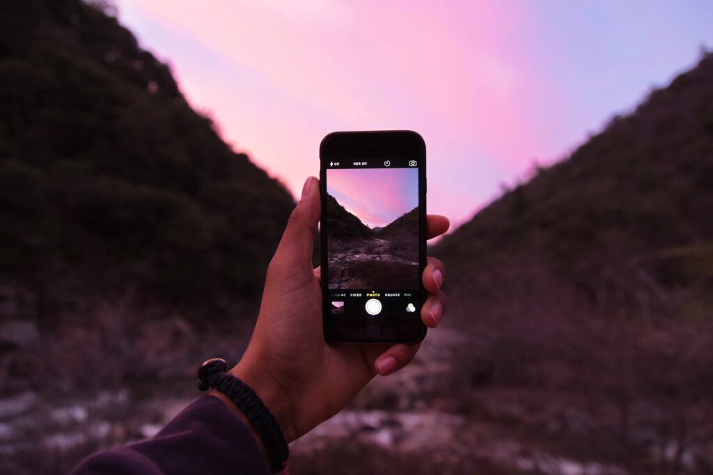 A cell phone camera snapping a purple sunset