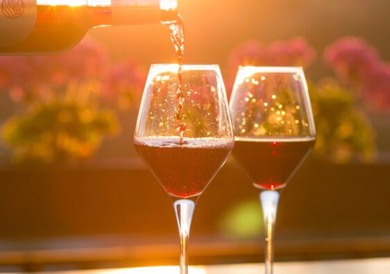 Pouring a glass of wine as the sun sets