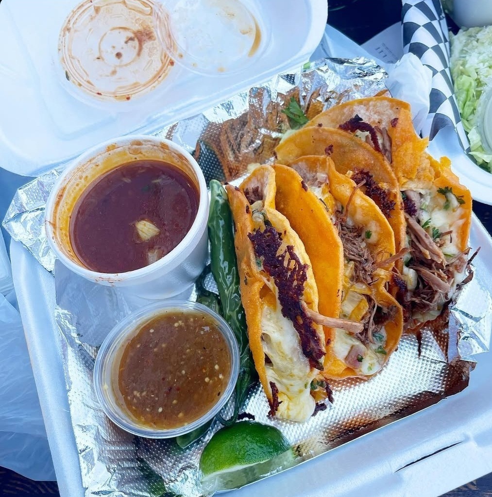 A plate of birria tacos and consommé for dipping