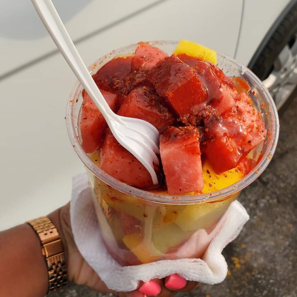 A cup of fruit with chamoy and Tajín on top