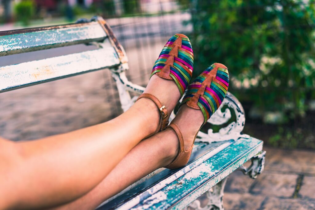 Woman wearing colorful shoes on a park bench