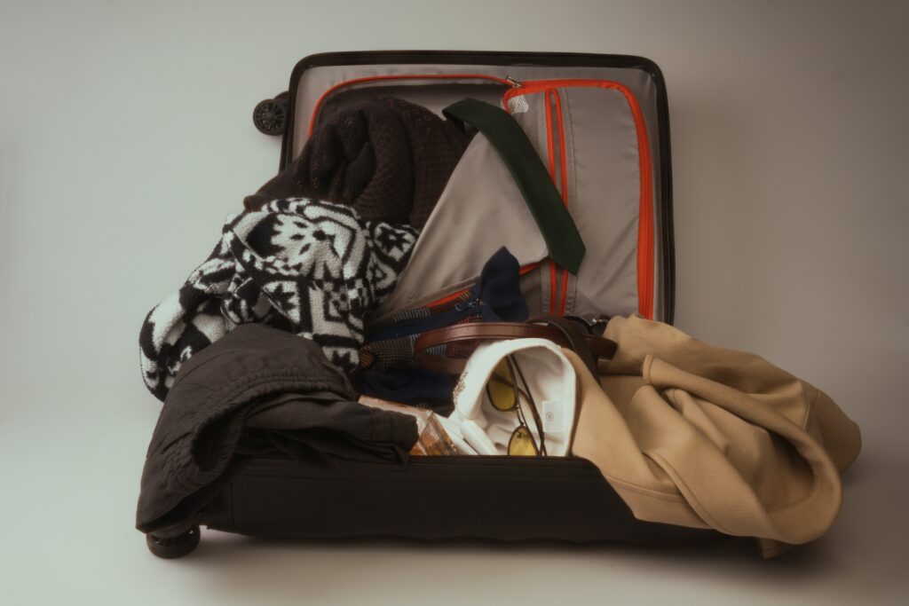 Overpacked suitcase with clothes and travel essentials