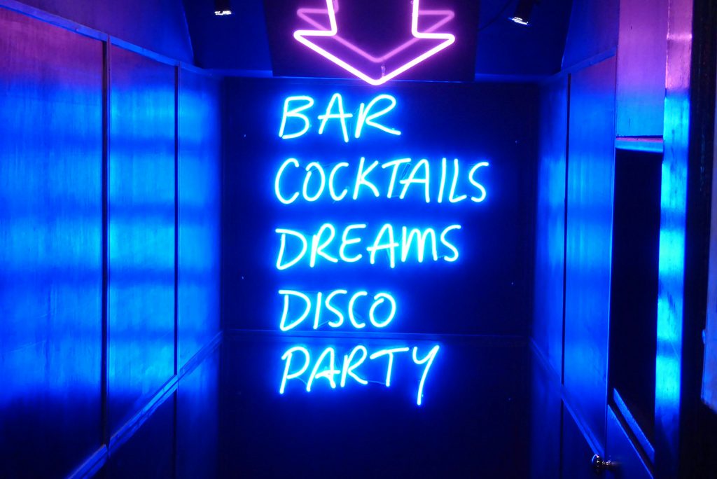 A blue and pink neon bar sign